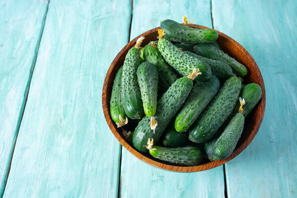 огурцы в чаше на деревянной поверхности
