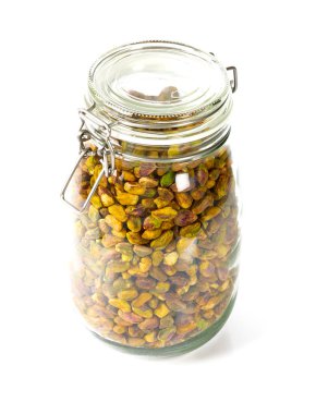 beyaz izole cam bir kavanozda ham antep fıstığı