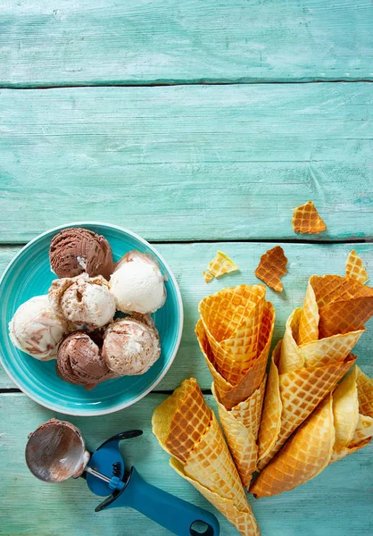 Ice cream and waffle cones on turquoise wooden surface — Stock Photo, Image