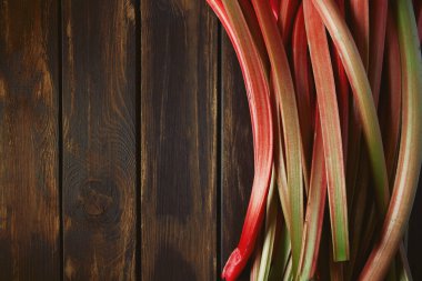 Taze rubarb, koyu ahşap bir yüzeye saplanır.