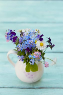 Turkuaz tahta yüzeyde bahar çiçekleri