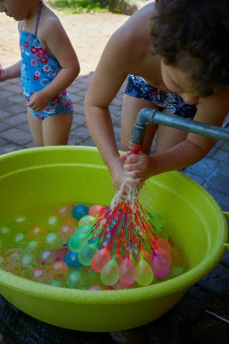 Su balonlarını dolduran tatlı çocuk..