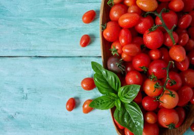 Turkuaz ahşap yüzeyde çeşitli minyatür domatesler