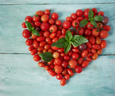 Turkuaz ahşap yüzeyde çeşitli minyatür domatesler