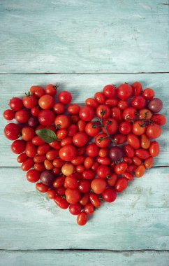 Turkuaz ahşap yüzeyde çeşitli minyatür domatesler