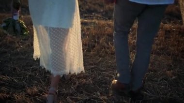 Hasat sahada çalışan insanlar sevgi dolu birkaç. Arkadan iki çekici sevgili görünüşü. Hasır şapka kız s başından düşüyor. İnsanlar birlikte eğleniyor. Yaz romantik akşam.