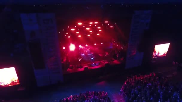 People dance at a music rock festival. Aerial view. Main stage. — Stock Video