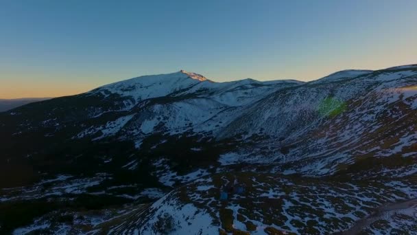 夕日や日の出の冬の雪に覆われた森や山林、後方の空中の平面図です。青の時間夕暮れや夜明け夕暮れのカルパティア山脈の雪シーズン開設。ウクライナ — ストック動画