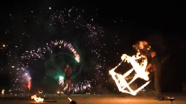 Tre artisti di spettacoli di fuoco in piedi in cerchio di fuoco, esibendosi. Un giocoliere bastoni ardenti, altri flagelli loro - rallentatore — Video Stock