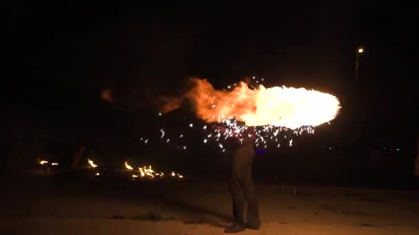 Trois artistes de spectacle de feu debout dans le cercle de feu, performant. L'un jongle avec des bâtons brûlants, l'autre les fléaux au ralenti — Video