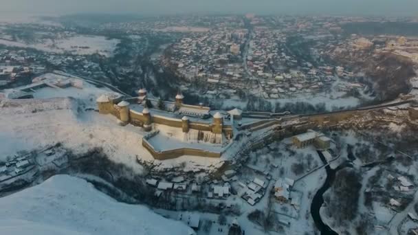 Vista aérea do castelo de Kamianets-Podilskyi na Ucrânia no inverno. A fortaleza localizada entre a natureza pitoresca na cidade histórica de Kamianets-Podilskyi, Ucrânia . — Vídeo de Stock