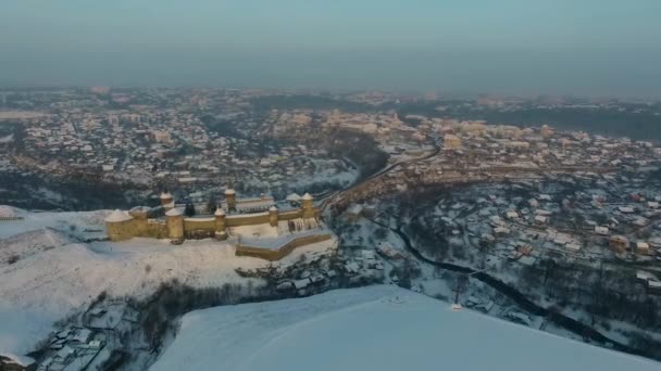 Vista aérea do castelo de Kamianets-Podilskyi na Ucrânia no inverno. A fortaleza localizada entre a natureza pitoresca na cidade histórica de Kamianets-Podilskyi, Ucrânia . — Vídeo de Stock