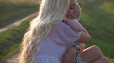 Güzel genç bir anne ile küçük oğlu gölün çevresinde güneşli bir günde yürümek.