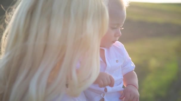 Passeggiata intorno al lago di una bella giovane madre con il suo piccolo figlio in una giornata di sole . — Video Stock