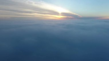 Gerçek havadan vurdu, drone güneşin doğuşunda bulutlarda uçar, kamera sisli olarak uçuyor. Şafak günışığında bulutlar gündoğumu, sırtlar ve tepeler üzerinde uçuş.