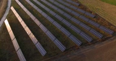 Güneş Panelleri Çiftliği güneş pili 4k Aerial view with sunlight. Avrupa 'da alan yenilenebilir yeşil alternatif enerji kavramı.