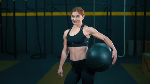 Ung kvinna med crossfit träningsboll visar liknande och leende — Stockvideo