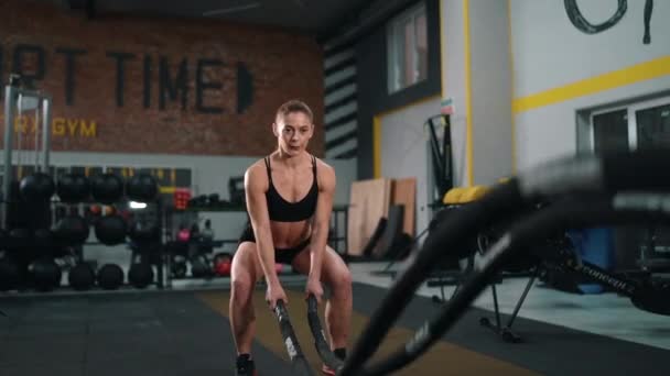 Mooi fitness meisje doet training met crossfit touw. Trainen in de sportschool. Langzame beweging — Stockvideo