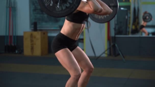 Atractiva mujer fitness montar bicicleta estática en el gimnasio. Dama delgada en bicicleta. Atleta femenina haciendo ejercicio intenso en bicicleta de gimnasio — Vídeos de Stock