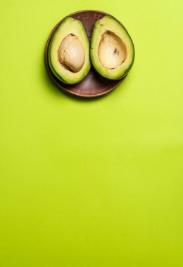Yeşil arka planda dilimlenmiş avokado.