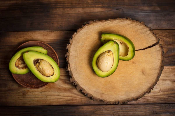 Avocat Vert Tranché Sur Une Surface Brune Bois — Photo