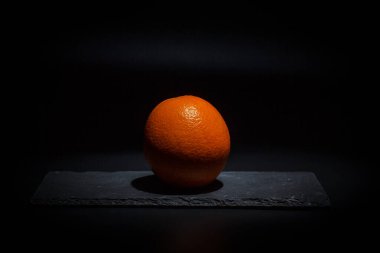 Siyah arka plan ve siyah yüzey üzerinde olgun turuncu
