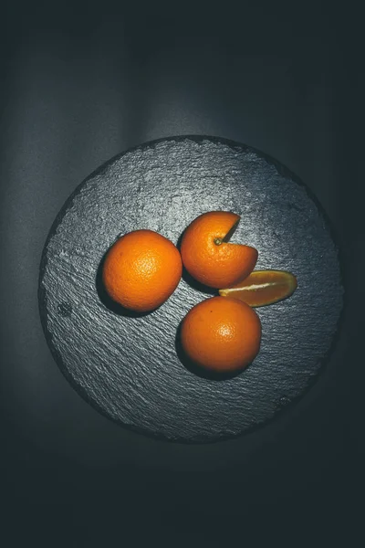 Tres Naranjas Yacen Sobre Una Superficie Negra — Foto de Stock