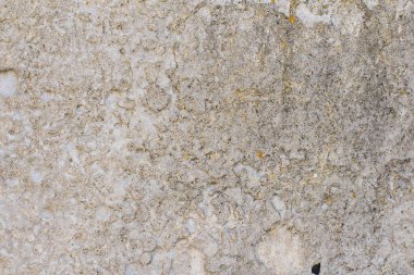 Çatlakları ve çizikleri olan eski beton bir duvarın bej rengi..
