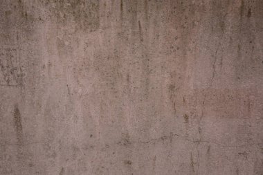 Çatlakları ve çizikleri olan eski beton bir duvarın bej rengi..