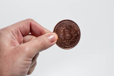 Beyaz arka planda Bitcoin 'i tutan el.