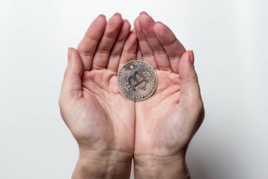 Bitcoin beyaz arka plandaki bir kızın ellerinde.