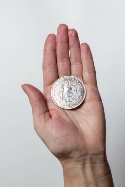 Bitcoin beyaz arka plandaki bir kızın ellerinde.