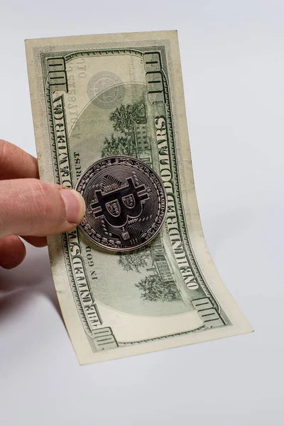 一个女孩手中的比特币和一个白色背景的美元 — 图库照片