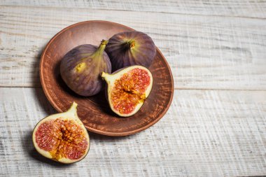 Beyaz ahşap yüzeyde lezzetli ve sağlıklı incirler.