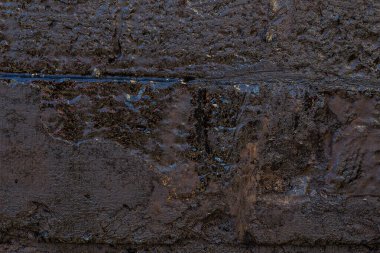 Çizik ve çatlaklarla kaplı siyah reçine duvar dokusu.