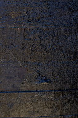 Çizik ve çatlaklarla kaplı siyah reçine duvar dokusu.