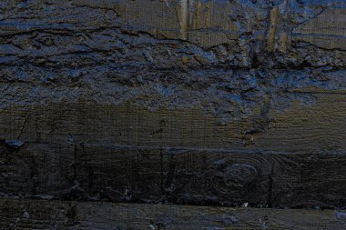 Çizik ve çatlaklarla kaplı siyah reçine duvar dokusu.