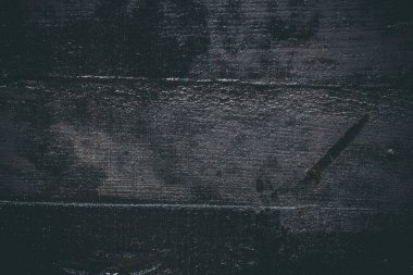 Çizik ve çatlaklarla kaplı siyah reçine duvar dokusu.