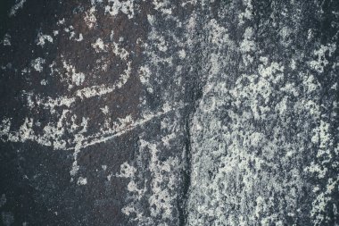 Çizik ve çatlaklarla kaplı siyah reçine duvar dokusu.