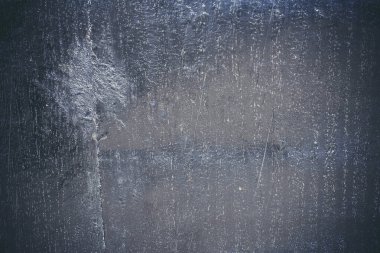 Çizik ve çatlaklarla kaplı siyah reçine duvar dokusu.