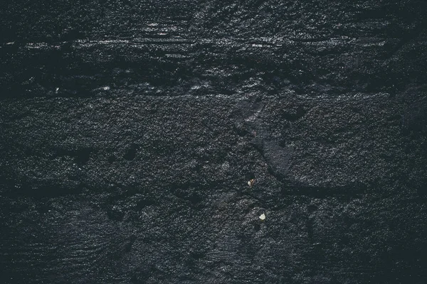 Black resin wall texture with scratches and cracks.