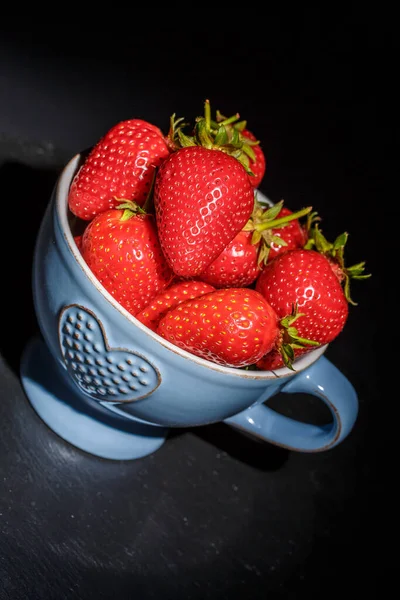 在黑色底色的盘子里放上成熟的红草莓 — 图库照片