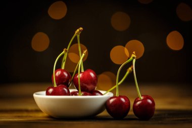 Kahverengi bir masada olgun kirazlar, güzel Bokeh