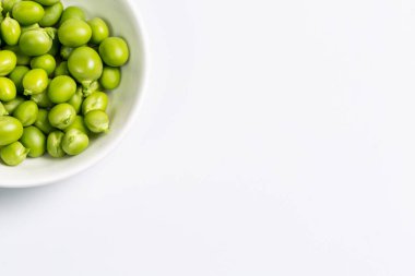Çiftlikte toplandıktan sonra beyaz bir zemin üzerinde olgun yeşil bezelyeler.