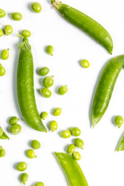 Çiftlikte toplandıktan sonra beyaz bir zemin üzerinde olgun yeşil bezelyeler.