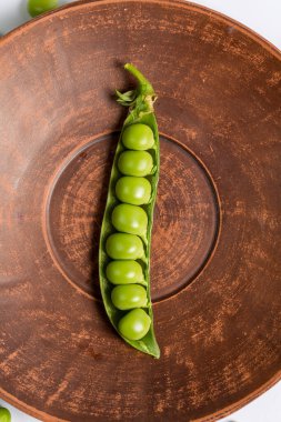 Çiftlikte toplandıktan sonra beyaz bir zemin üzerinde olgun yeşil bezelyeler.