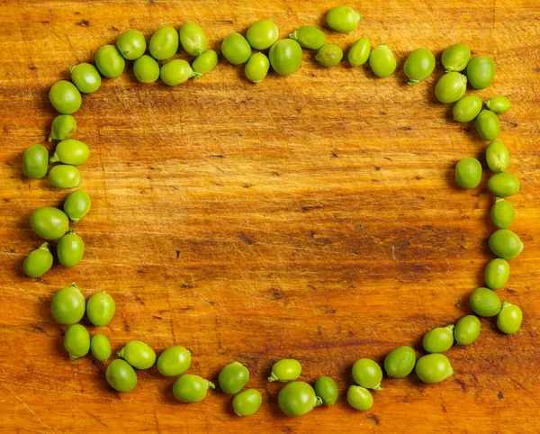 調理のための木製の表面上に緑のエンドウ豆を熟す — ストック写真