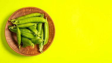 Yeşil bir zemin üzerinde olgun yeşil bezelyeler