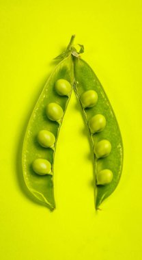 Yeşil bir zemin üzerinde olgun yeşil bezelyeler