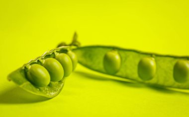 Yeşil bir zemin üzerinde olgun yeşil bezelyeler